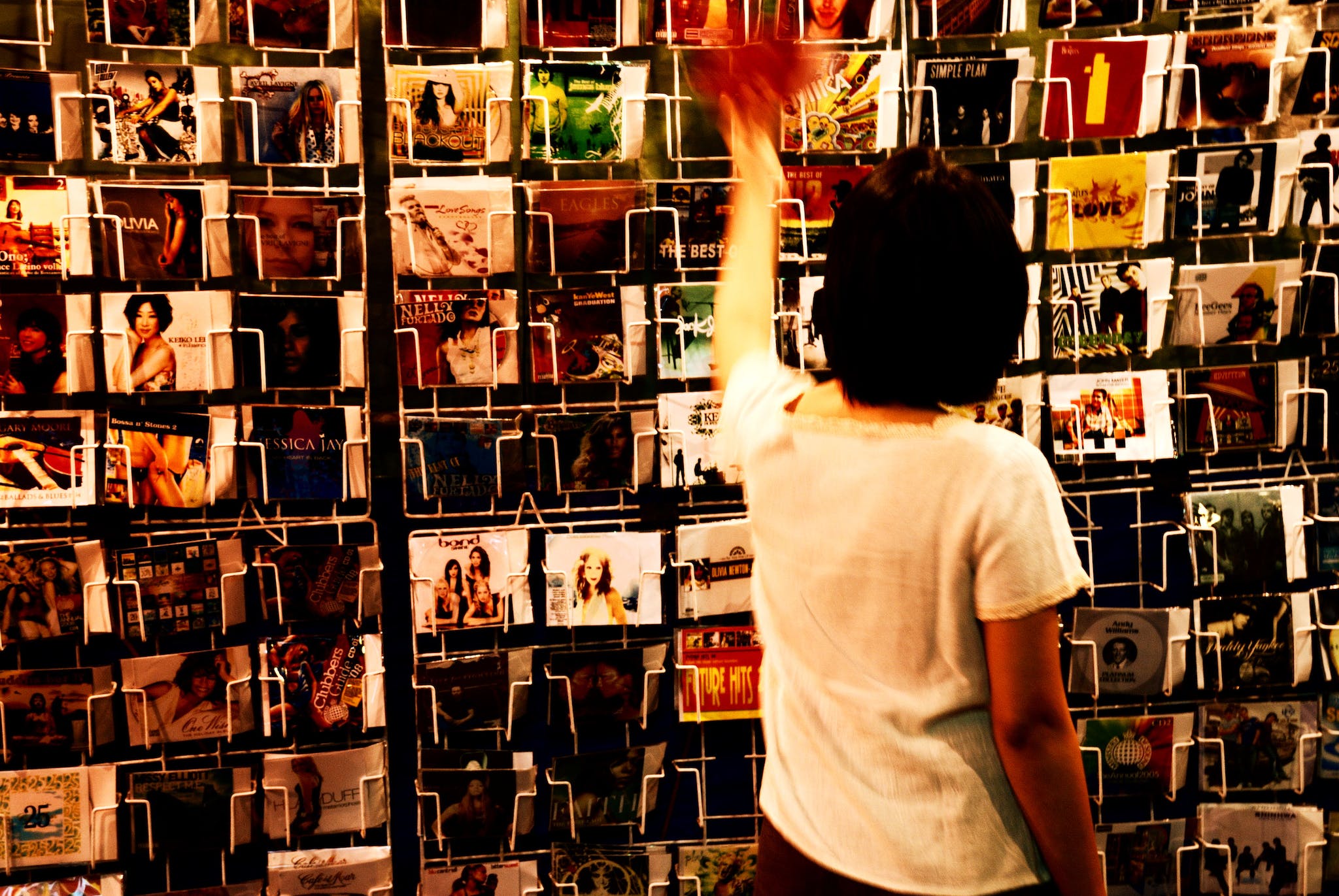 Person Wearing White Shirt Holding Vinyl Albums